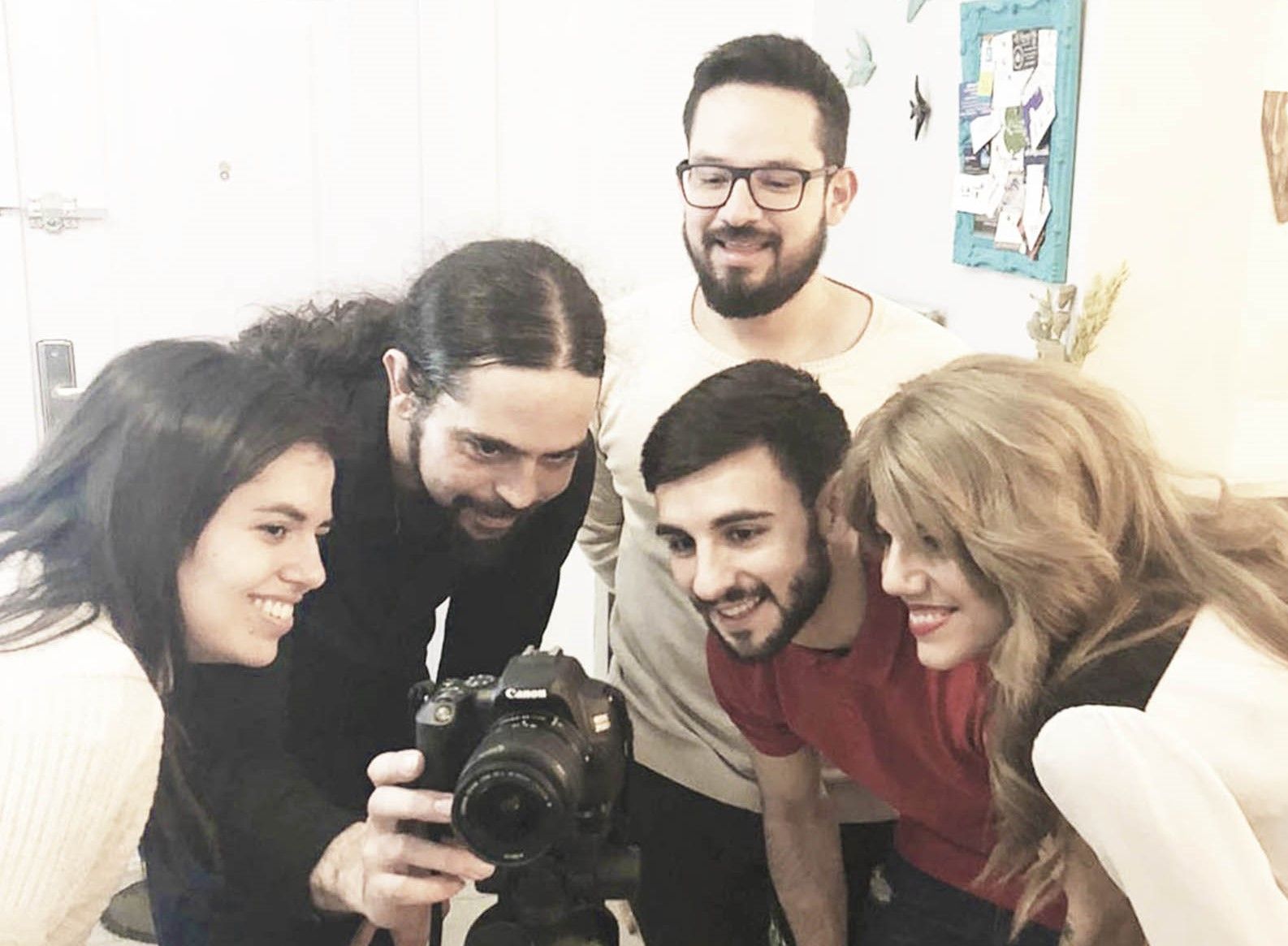 Fotografía de algunos profesores de Artes Creativas, todos muy sonrientes y felices mirando por una cámara de fotos