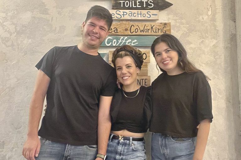 Fotografía de tres profesores de Artes Creativas, muy sonrientes y vestidos con vaqueros y camisetas negra