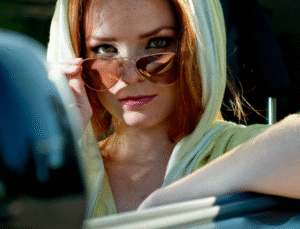 chica pelirroja glamurosa en un coche